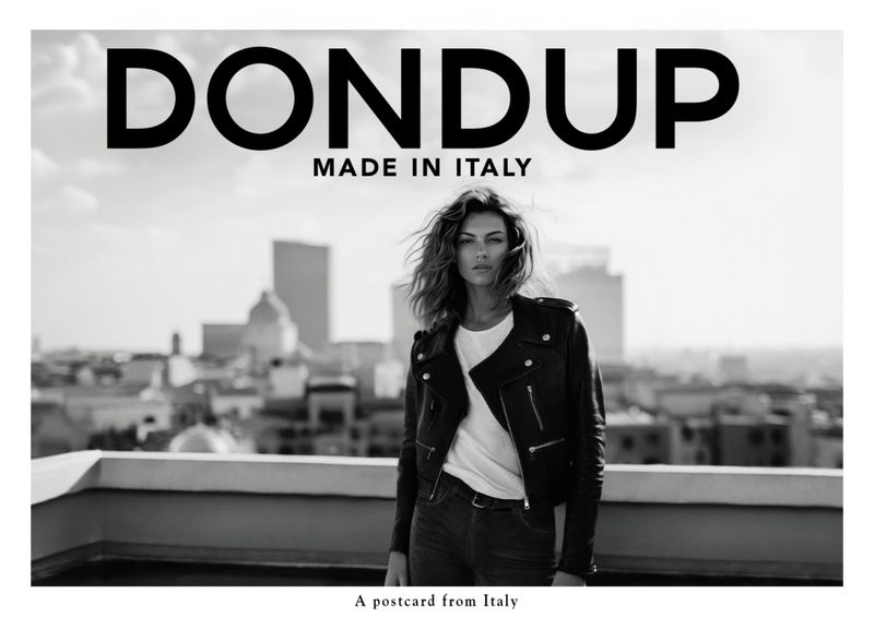Stylish female model wearing a black leather jacket and white t-shirt by DONDUP, set against a chic urban skyline. 
